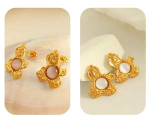 Detailed macro view of gold flower earrings with pink and white opalescent stones