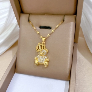 Macro shot of gold-plated bear necklace with pavé crystal crown on velvet background