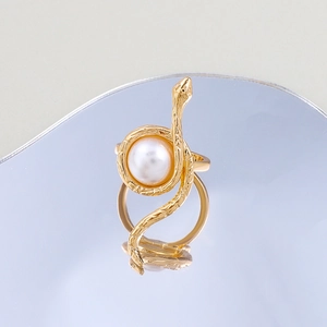 Detailed view of golden snake ring featuring scale texture and a white pearl inlay