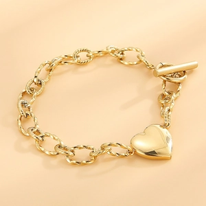 Détail d'un bracelet gourmette doré en acier inoxydable avec pendentif cœur et fermoir OT