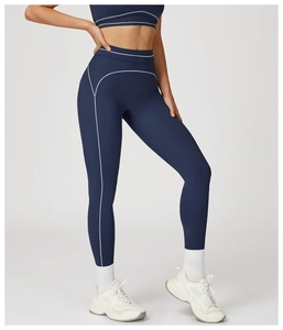 Detail of high-waisted navy yoga leggings featuring white contrast stitching and matte fabric