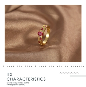 Macro detail of vintage gold ring featuring oval red zircon and pavé crystal settings