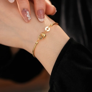 Close-up of a luxury 18K gold plated bamboo bracelet with zircon charms on a wrist