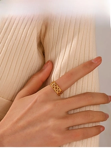 Detail view of 18K gold plated braided ring showing hollow texture on models finger