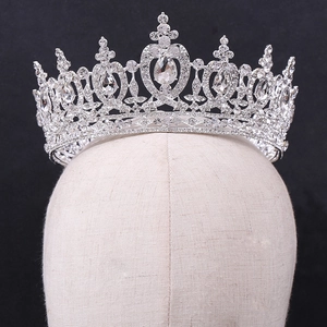 Detail of silver bridal crown with sparkling rhinestones on a beige display head