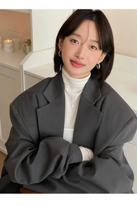 Minimalist silver teardrop earrings worn with an oversized dark grey blazer and white top