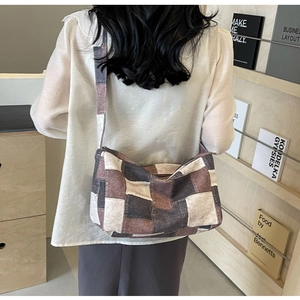 Détail du sac à bandoulière rétro en toile à damier porté par un mannequin en décor