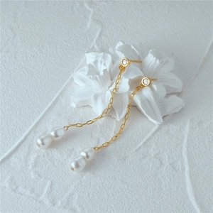 Detail of luxury S925 silver pearl drop earrings with gold tassel chains and zircon accents