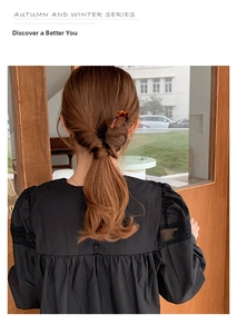 Close-up of a tortoiseshell U-shaped hair pin used in a minimalist bun hairstyle