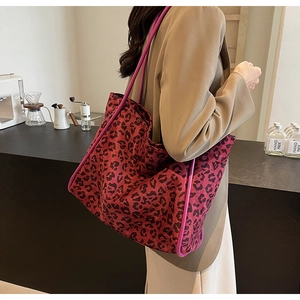 Detail of red leopard print tote bag styled in a cozy cafe setting for a fashion look