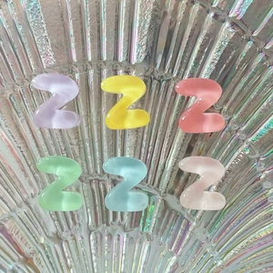 Close-up of mini resin alphabet Z charms in colorful transparent finishes for DIY crafts