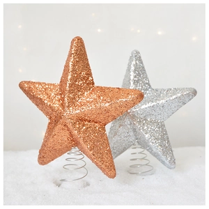 Detail of glitter star tree toppers in gold and silver with metal spring bases