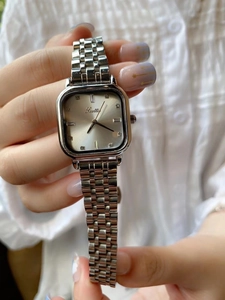 Detail of square silver ladies watch with champagne dial and stainless steel strap