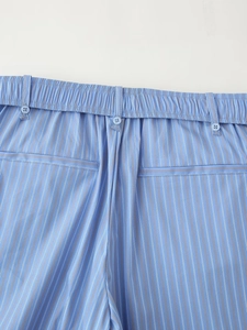 Detail view of elastic waist with button and blue striped pattern on sleepwear trousers