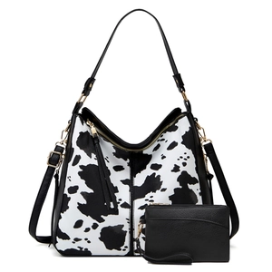 Detail of cow print tote bag and black pouch set with premium golden hardware