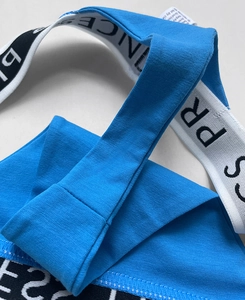 Close-up of blue cotton fabric with PRINCESS lettered elastic waistband and soft texture