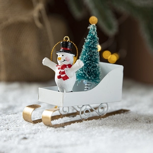 Iron snowman figurine on a white metal sleigh with a mini Christmas tree and gold lanyard