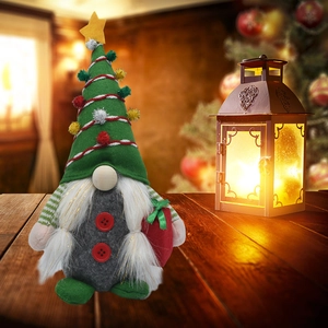 Gnomes de Noël en feutre rouge, vert et gris sur une table en bois avec décor chaleureux