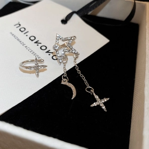 Detail view of silver sparkling zircon star and moon tassel earring jewelry set