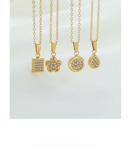 Detailed view of four geometric gold-plated pendants with cubic zirconia on silk background