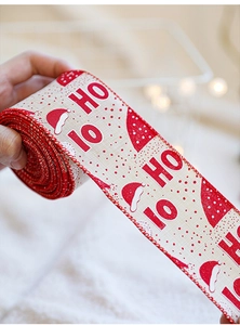 Close-up of red and beige Christmas ribbon with HO HO print and burlap texture