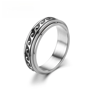 Macro shot of silver and black stainless steel rotating ring with wave pattern design