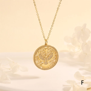 Macro detail of gold dove and cross pendant with micro-paved cubic zirconia stones