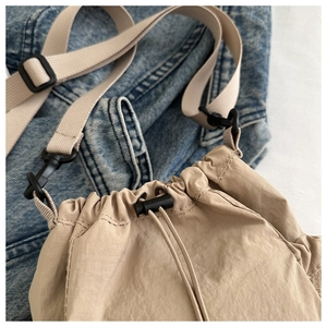 Details der beigen Nylon-Beuteltasche mit Kordelzug und verstellbarem Schultergurt