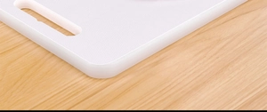 Detailed close-up of white anti-bacterial PE plastic cutting board with handle hole