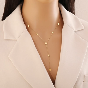 Elegant gold titanium heart Y-necklace with small metal charms shown on a model neck