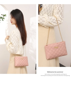 Detail of pink quilted crossbody bag featuring elegant gold chain strap and stitching