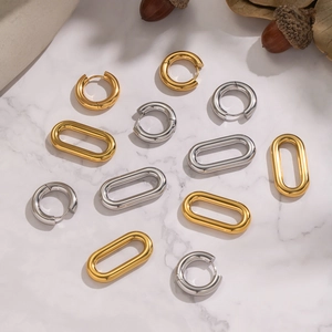 Two-tone 18K gold and silver stainless steel hoop earrings on marble surface