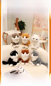 Close-up of six realistic plush kittens in various colors on a soft white sofa