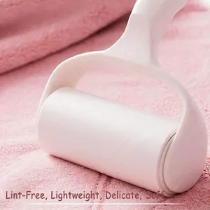 Microfiber lint roller removing hair from pink coral fleece fabric towel effectively