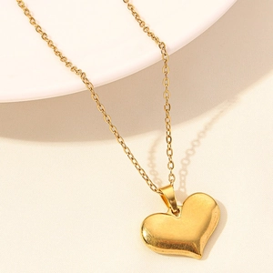 Close-up of polished 18k gold plated stainless steel heart pendant necklace with mirror finish