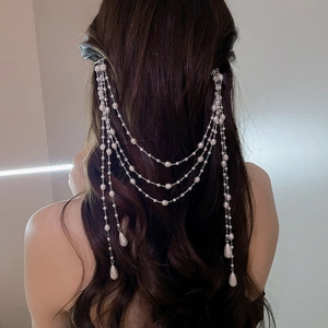 Detail view of elegant silver long tassel hair clip with white pearls and teardrop beads
