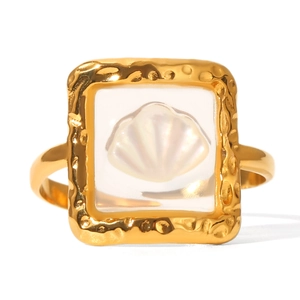 Detail view of golden hammered ring with transparent resin and white seashell inlay