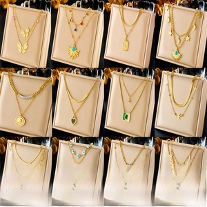 Collection of layered gold necklaces with butterfly, star, and turquoise pendants