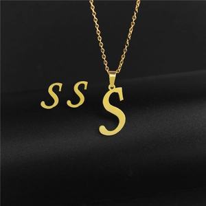 Detailed close-up of golden letter S pendant necklace and matching stud earrings set