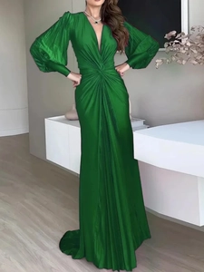 Detail of a deep green satin maxi dress showing pleated waist and long lantern sleeves
