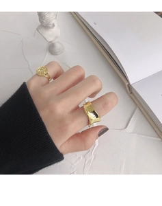 Minimalist gold plated wave ring and round embossed signet ring worn for a stylish look