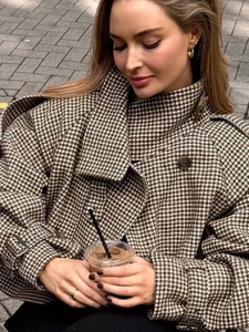 Detail of vintage brown houndstooth wool coat with stand collar and epaulettes