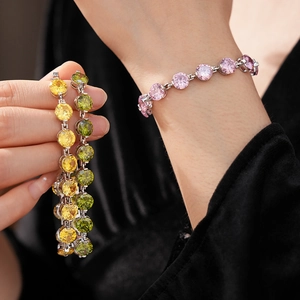 Detailed view of silver bracelets with colorful round zircons worn on a wrist