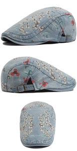 Detail of washed denim beret with floral print and adjustable metal side buckle