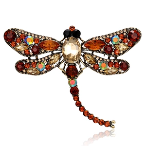 Detail of vintage dragonfly brooch featuring amber rhinestones and bronze alloy base
