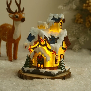 Detailed view of a glowing resin Christmas miniature house with LED warm light and snow effects