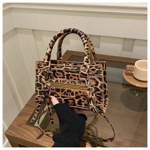 Dettaglio mini borsa city leopardata con doppi manici e borchie in stile biker