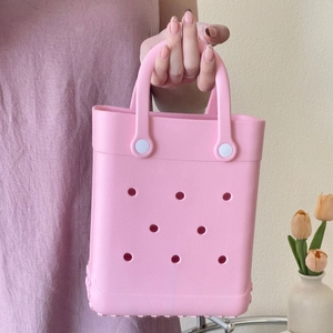 Detail shot of a pink waterproof EVA tote bag with circular cutouts and sturdy handles