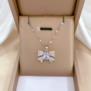Close-up of a silver titanium steel butterfly necklace with diamonds in a gift box
