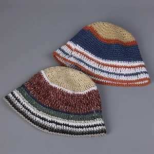 Detailed view showing textures of two colorful striped handmade woven straw bucket hats.